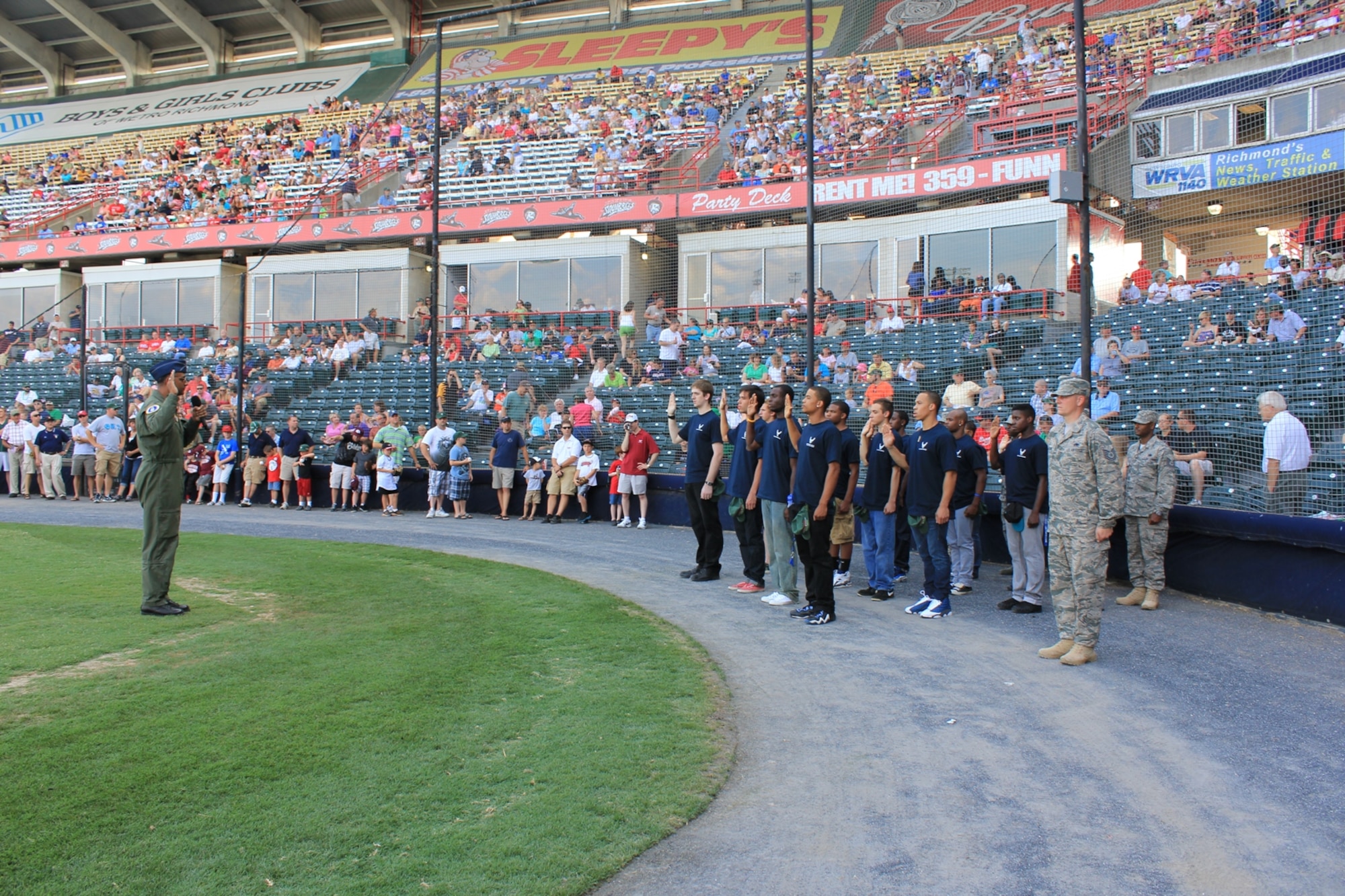 Lt. Col. Ravi Chaudhary, 317th RCS commander, administered the oath of enlistment to13 new recruits in front of 9,000 Richmond Squirrels baseball fans in Richmond, Va., during Military Appreciation Night. This was his first Delayed Enlistment Program swear-in. At the conclusion of the oath, the new recruits received a standing ovation. (USAF photo/courtesy photo) 