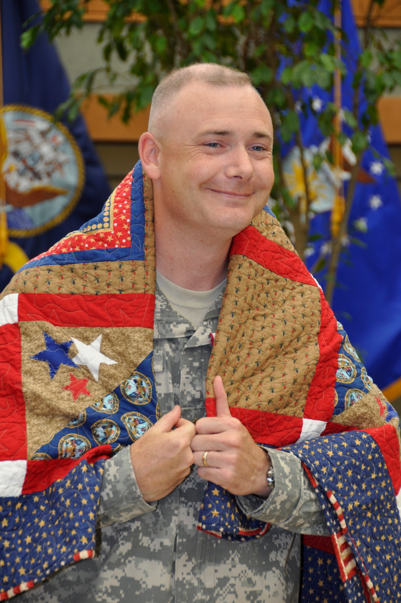 Army Chap. (Maj.) Charles Wallace wraps a Quilt of Valor around his shoulders June 29, 2011 at the Charles C. Carson Center for Mortuary Affairs. Chaplain Wallace was presented the Quilt on behalf of the Quilts of Valor Foundation, a non-profit organization, with the help of volunteers, make quilts for those affected by war. The chaplain has been supporting families of fallen servicemembers who travel to Dover Air Force Base, Del., to witness the dignified transfer of a loved one. (U.S. Air Force photo/Tech. Sgt. Michael Stewart)