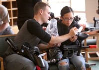 Danny Goff helps Senior Airman Sophia Joanis load up her bullets for a paintball battle at the at the Lackland Outdoor Recreation Center June 23. (U.S. Air Force photo/Robbin Cresswell)