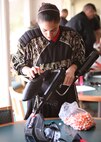 Christie Vera loads up her weaponry to prepare for paintball combat at the Lackland Outdoor Recreation Center June 23. (U.S. Air Force photo/Robbin Cresswell)