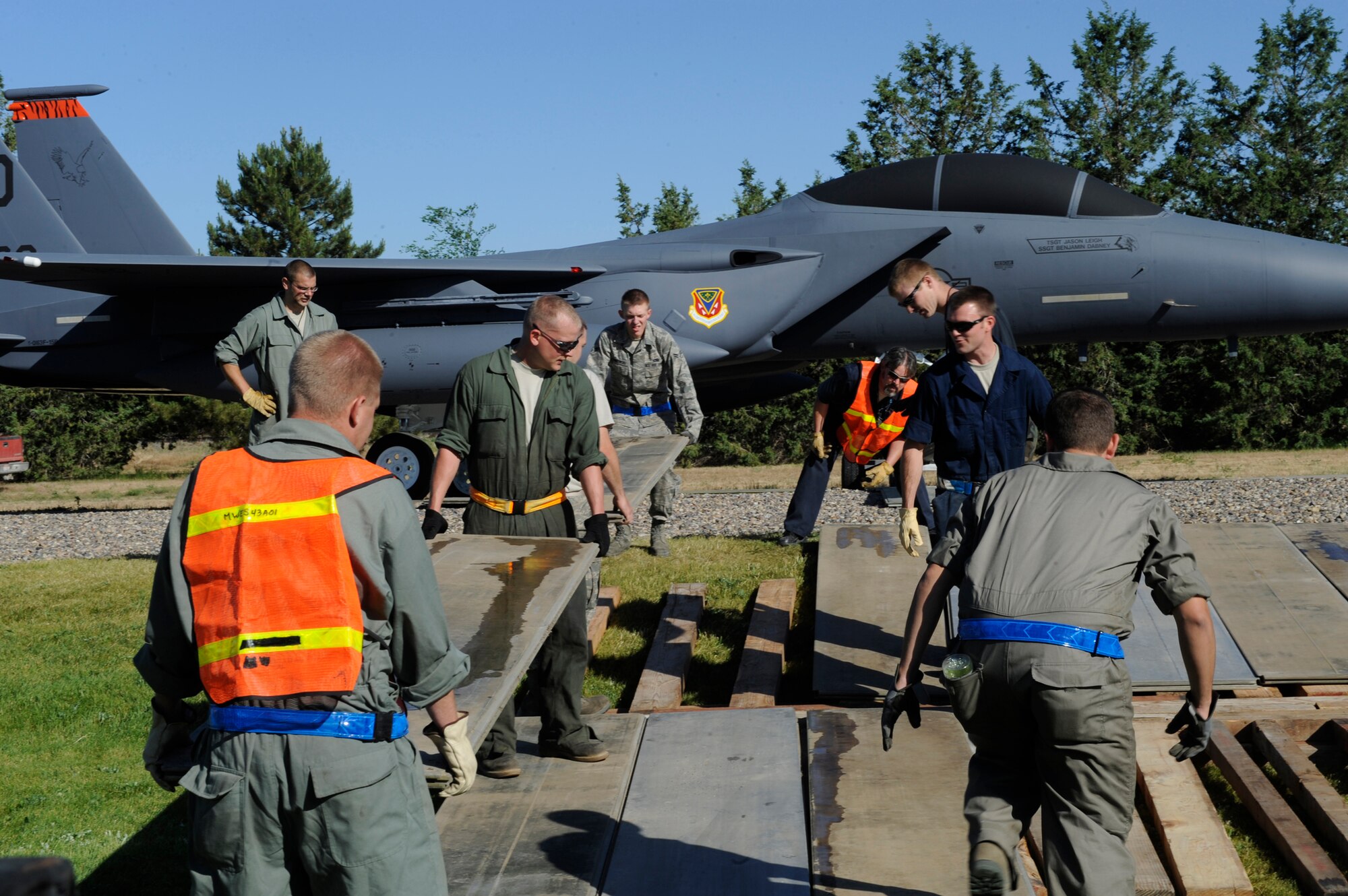 MOUNTAIN HOME AIR FORCE BASE, Idaho – Gunfighters build a ramp in order to safely maneuver the newest, nearly 10,000 pound, static display down a grassy hill here June 25. The F-15E Strike Eagle was flown to Mountain Home in 2008 and has since been selected to bear with the names of Airmen who have died or have provided significant contributions to the base. (U.S. Air Force photo by Senior Airman Angelina Drake)