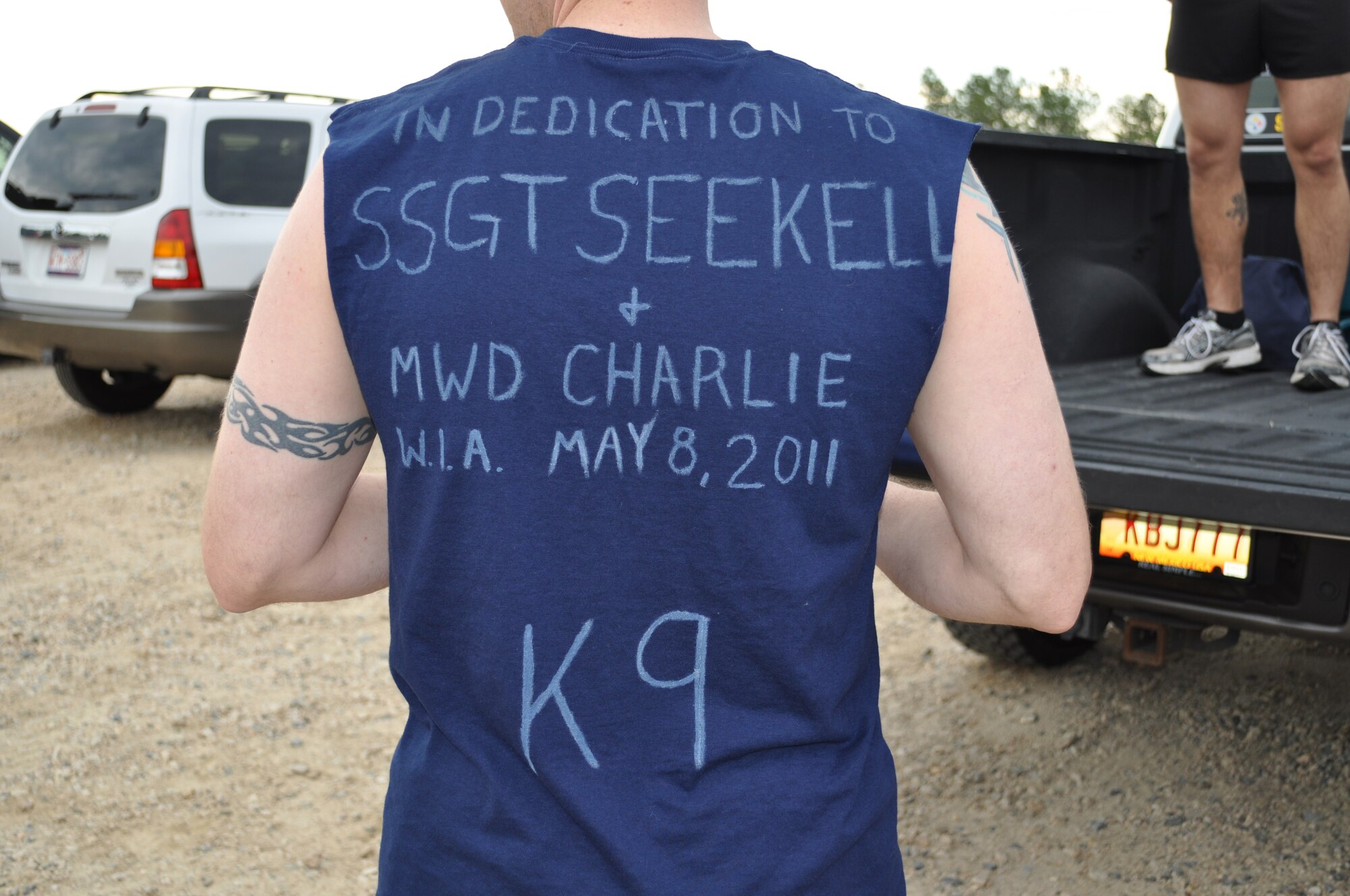 WINNSBORO, S.C.  - Master Sgt. Nathan Nash, 4th Security Forces Squadron Military Working Dogs section, shows off his shirt before competing in the Super Spartan Race at Carolina Adventure Park in Winnsboro, S.C., June 25, 2011. Eight Airmen from the K-9 section competed in the grueling eight-mile race in dedication to Staff Sgt. Benjamin Seekell and military working dog, Charlie, who were wounded in Afghanistan in May. The race included maneuvering eight foot-high walls, jumping from 10 -15 foot cliffs and a 50 meter low-crawl. (Courtesy Photo)