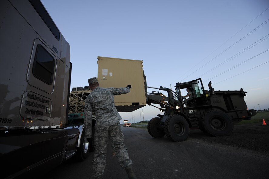MINOT AIR FORCE BASE, N.D. -- Air Force Global Strike Command Airmen with assistance of Airmen from the 49th Material Maintenance Squadron stationed at Holloman Air Force Base, N.M., unload reverse osmosis water purification units and prepare an area tonight for its placement here June 29. The technical experts from Holloman AFB will help in assembling the ROWPUs to provide potable water to Minot AFB. (U.S. Air Force Photo/Staff Sgt. John D. Comer)