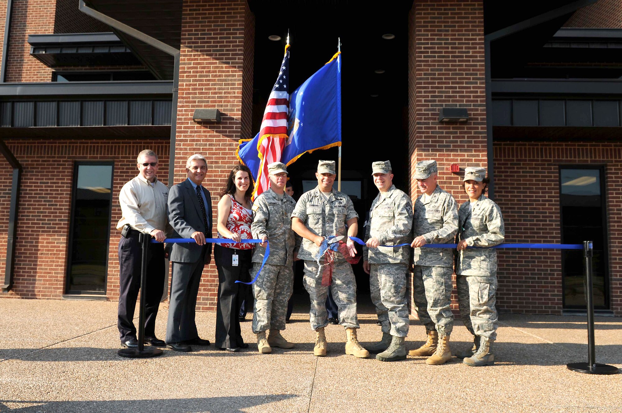 GOODFELLOW AIR FORCE BASE, Texas -- Col. Mark Damiano, 17th Training Wing Commander, and other wing and community leaders, mark the grand opening of a new 200-room dormitory here during a ribbon cutting ceremony June 29.  The dorm, which was funded by 2009 economic stimulus dollars, is a quality of life improvement and meets the latest energy efficiency standards. (U.S. Air Force photo/Staff Sgt. Heather L. Rodgers)
