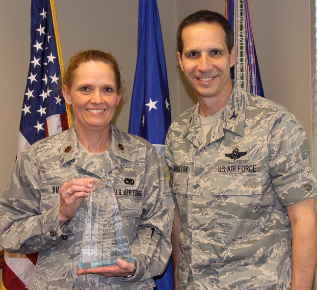 Col. Jeffrey T. Pennington, 911th Airlift Wing commander, presents Maj. Tanaka H. Dunn with the AFRC Process Manager of the Year award for 2010, June 29, 2011.  The award recognizes Maj. Dunn for her outstanding contribution to the AFRC continuous process improvement program.  Taking over the position in January 2010, Maj. Dunn works with senior leadership on strategic planning, instructs process improvement classes, and facilitates process improvement events.  The position is geared toward finding more effective and efficient ways of completing mission essential tasks.(U.S. Air Force photo/by Senior Airman Melissa Knox)