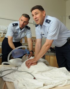 From left, Col. Eric Stone, 633rd Medical Group commander, and Col. Korvin Auch, 633rd Air Base Wing commander, simulate administering CPR during the medical group visit at Langley Air Force Base, Va., June 27, 2011. The base commander toured the facility to establish a rapport and receive a mission briefing from the staff. (U.S. Air Force photo by Airman 1st Class Racheal Watson/Released)