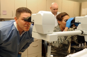 From left, Col. Korvin Auch, 633rd Air Base Wing commander, and Staff Sgt. Ayesha Garrett, 633rd Medical Support Squadron noncommissioned officer in charge of microbiology, examine bacteria during a visit to the 633rd Medical Group at Langley Air Force Base, Va., June 27, 2011. The commander’s base tour focused on the wing's mission to deliver well-prepared Airmen and Soldiers.  (U.S. Air Force photo by Airman 1st Class Racheal Watson/Released)