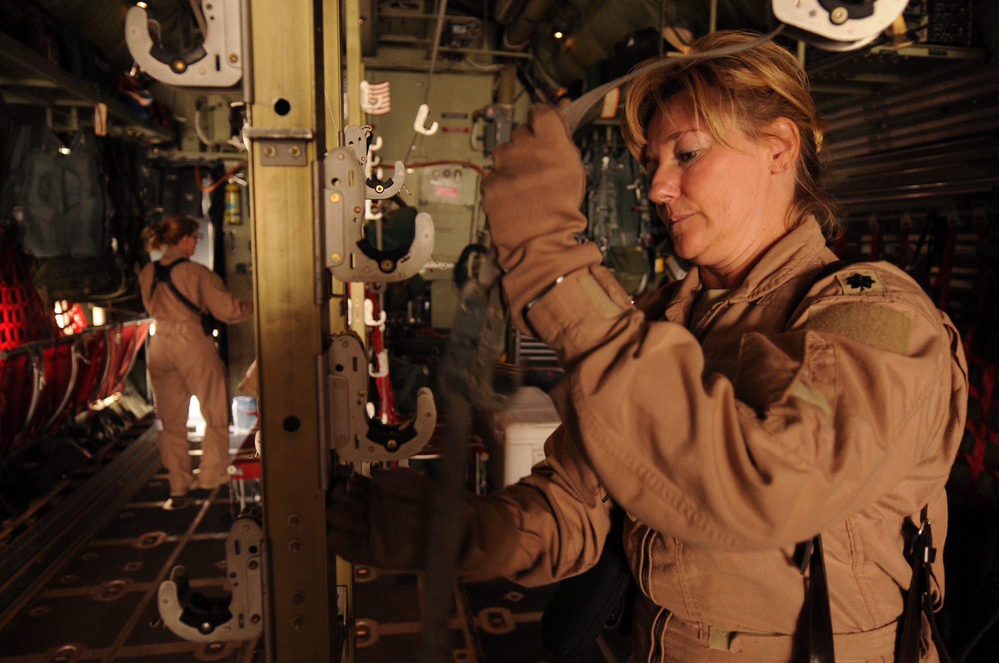 Lt. Col. Sherry Hemby, 455th Expeditionary Aeromedical Evacuation Flight commander, ensures the brackets are in working order on a C-130 Hercules for an aeromedical evacuation flight to Bagram Airfield, Afghanistan, June 28, 2011. (U.S. Air Force photo by Senior Airman Krista Rose)