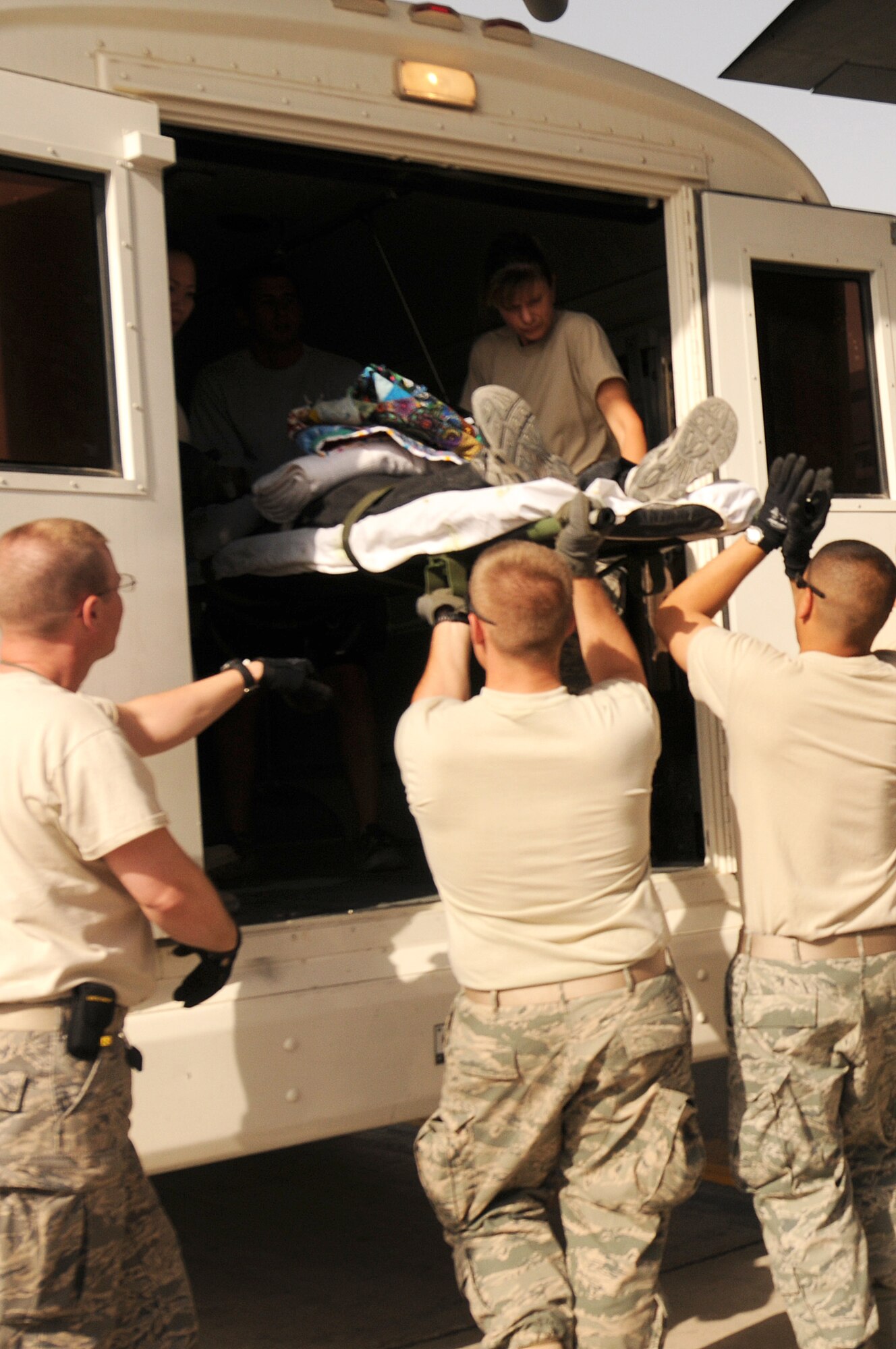 Members of the 455th Contingency Aeromedical Staging Facility load litter patients onto a bus for transport to the Craig Joint Theater Hospital at Bagram Airfield, Afghanistan, June 28, 2011 after an aeromedical flight. (U.S. Air Force photo by Senior Airman Krista Rose)