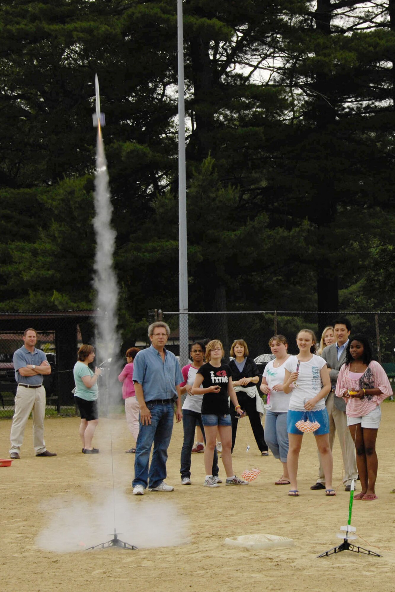 HANSCOM AIR FORCE BASE, Mass – Students from Fred Lipton’s class watch as rockets launch outside of Hanscom Middle School June 24. The class received rockets and supplies after they were awarded a grant from the Lexington-Concord Young AFCEANs to teach “hands on science” to students. The middle school was one of three schools in the state that were chosen for the special program. (U.S. Air Force photo by Linda LaBonte Britt)