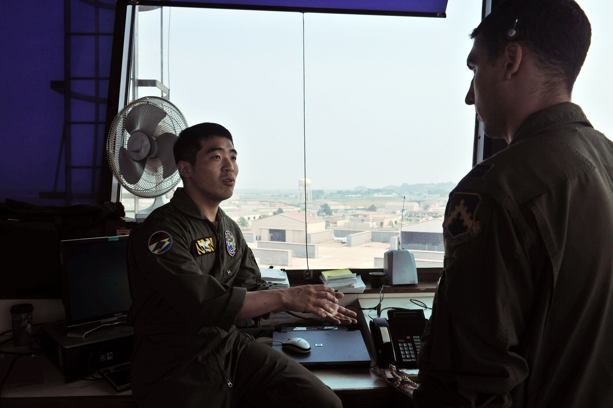 KUNSAN AIR BASE, Republic of Korea – Capt. Bobby Newman, 8th Fighter Wing supervisor of flying, talks to Capt. Jung Hak Song, 38th Fighter Group, about his mission as the supervisor of flying during the pilot exchange program here June 28. The exchange program provides the two countries a way to foster friendship while learning new ideas, tactics and techniques from each other.  (U.S. Air Force photo/Senior Airman Brittany Y. Bateman)