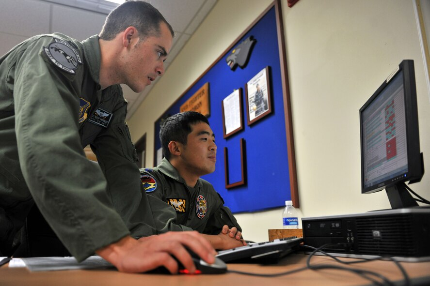 KUNSAN AIR BASE, Republic of Korea -- Capt. Jake Pippenger, 35th Fighter Squadron scheduler, shows Capt. Jung Hak Song, 38th Fighter Group, the ins and outs of scheduling during the pilot exchange program here June 28. The exchange program provides the two countries a way to foster friendship while learning new ideas, tactics and techniques from each other. (U.S. Air Force photo/Senior Airman Brittany Y. Bateman) 