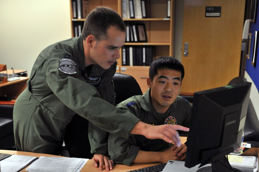 KUNSAN AIR BASE, Republic of Korea -- Capt. Jake Pippenger, 35th Fighter Squadron scheduler, shows Capt. Jung Hak Song, 38th Fighter Group, the ins and outs of scheduling during the pilot exchange program here June 28. The exchange program provides the two countries a way to foster friendship while learning new ideas, tactics and techniques from each other. (U.S. Air Force photo/Senior Airman Brittany Y. Bateman) 