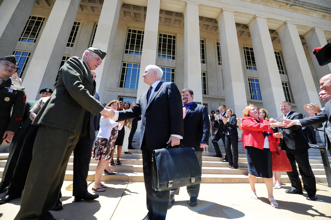 Defense Secretary Robert M. Gates shakes hands with Marine Corps Lt. Gen. John Kelly, his senior military sssistant, as he departs the Pentagon for a final time as secretary, June 30, 2011.