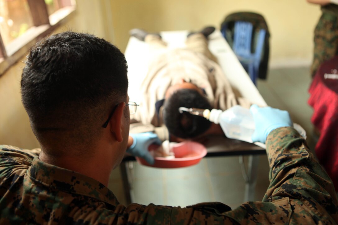 Petty Officer 3rd Class Julio Trujillo, a hospital corpsman with Battalion Landing Team 2nd Battalion, 5th Marines, 31st Marine Expeditionary Unit, rinses out a head gash of a Cambodian villager during a medical civil action project, March 1. Marines and Sailors of the 31st MEU worked alongside the Royal Cambodian Navy and the Cambodian Children’s Surgical Center during the MEDCAP. The MEDCAP is a three-day event in support of the Cambodian Maritime Exercise 2011. The Cambodian MAREX ‘11 is part of the U.S. Pacific Command’s Theater Security Cooperation Program, and provides unique and dynamic opportunities for collaboration between the Cambodian and U.S. military, while promoting relationship-building between militaries and local communities.