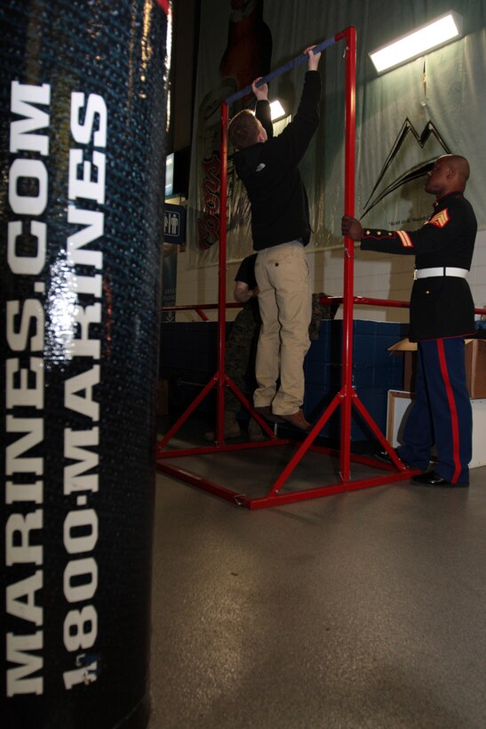 Sergeant Paul J. Cunningham, a recruiter with Marine Corps Recruiting Station Albany, N.Y., supervises a pull-up challenge for an Albany area high school student at the Times Union Center during the Section II Boys Basketball semifinals. Marines with Recruiting Station Albany attend several events a month at the Times Union Center to raise awareness of the Marine Corps and to generate interest in the opportunities the Marine Corps provides.