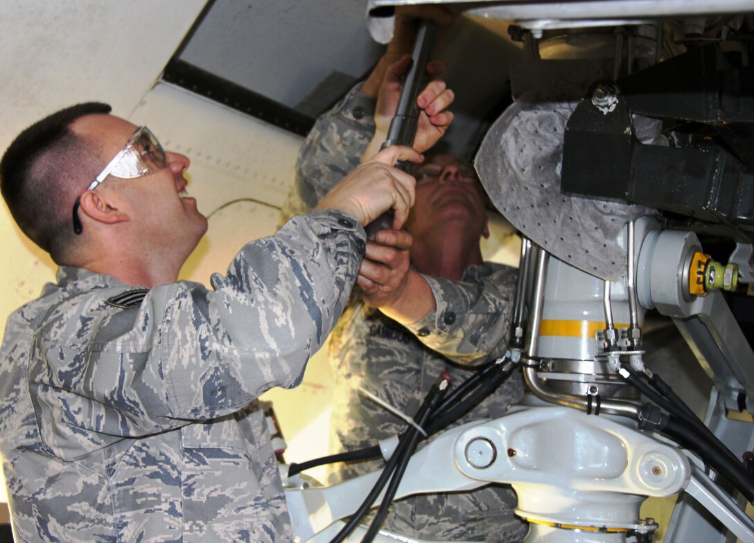 Senior Airman Eric Adams and Master Sgt. Kevin Gabioud use a large ratchet to tighten the bolts on new C-9C landing gear.  The procedure is done every ten years on the C-9C regardless of flying hours, Sergeant Gabioud said.  The 932nd Airlift Wing is an Air Force Reserve unit whose mission is distinguished visitor airlift.  The 932nd AW also flies the C-40. (U.S. Air Force photo/Tech. Sgt. Dan Oliver) 