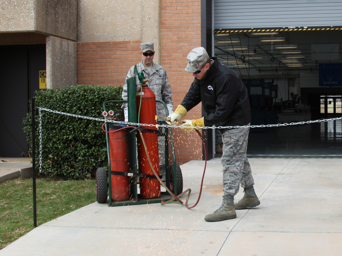 Brig. Gen. Darryl Burke, 82nd Training Wing commander, cuts a chain with a torch Feb. 25 during the aircraft metals technology course relocation ceremony and ribbon cutting. The course is taught over a span of 96 academic days and features nine blocks of instruction to teach Airmen the basics of aircraft metals technology. The course is on track for graduating 270 Airmen each year; the first class is scheduled to graduate April 14.