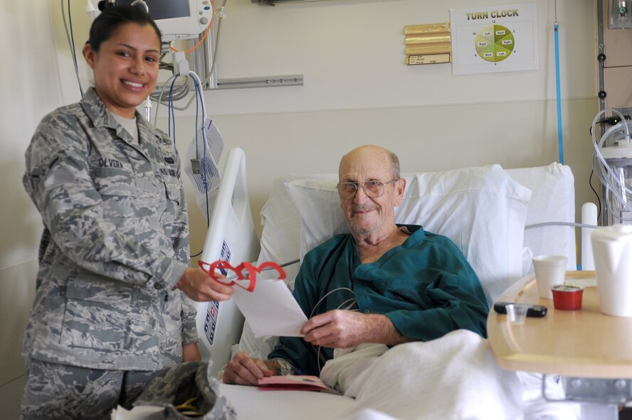 U.S. Air Force Airman Lidia Olvera, Knowledge Operations Management, 4th Combat Camera Squadron, March Air Reserve Base, Calif., gives a Valentine's Day card to U.S. Army Cpl. Bob Ring, a Vietnam POW at Loma Linda Veterans Hospital, Loma Linda, Calif., Feb. 16, 2011. (U.S. Air Force photo by Tech. Sgt. Christine Jones/Released)