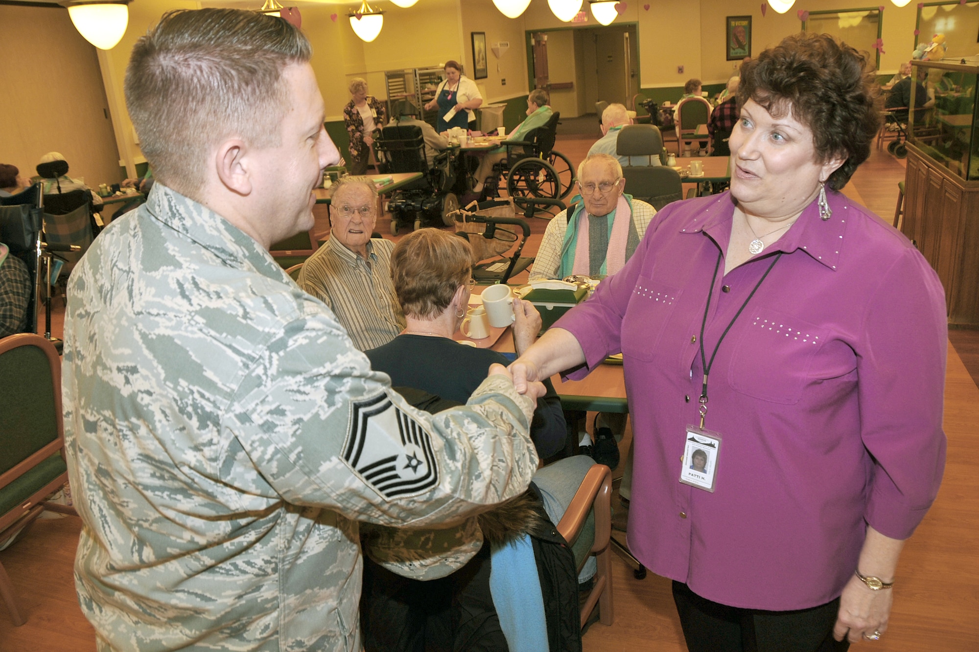Senior Master Sgt. Matthew Becker is greeted Feb. 16, 2011, by Patti Howe, a volunteer coordinator at the Eastern Nebraska Veterans Home near Offutt Air Force Base, Neb., during one of his periodic visits to the home. Sergeant Becker is assigned to the 55th Aircraft Maintenance Squadron. (U.S. Air Force photo/Jeff W. Gates)
