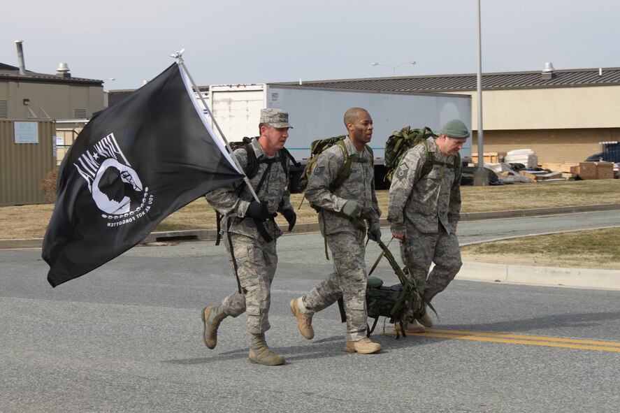 Senior Master Sgt. Gene Elking, 436th Logistics Readiness Squadron, carries a POW/MIA Flag while Tech. Sgt. Michael Spencer and Master Sgt. Dave Jackson, 512th LRS, carry an extra 30-pound ruck during the 12th Annual Chosin Reservoir Commemorative Ruck March here Feb. 26. Teams consisted on four marchers with the exception of this one in which the fuels flight troops were representing those missing in action. (U.S. Air Force photo/Christin Michaud)