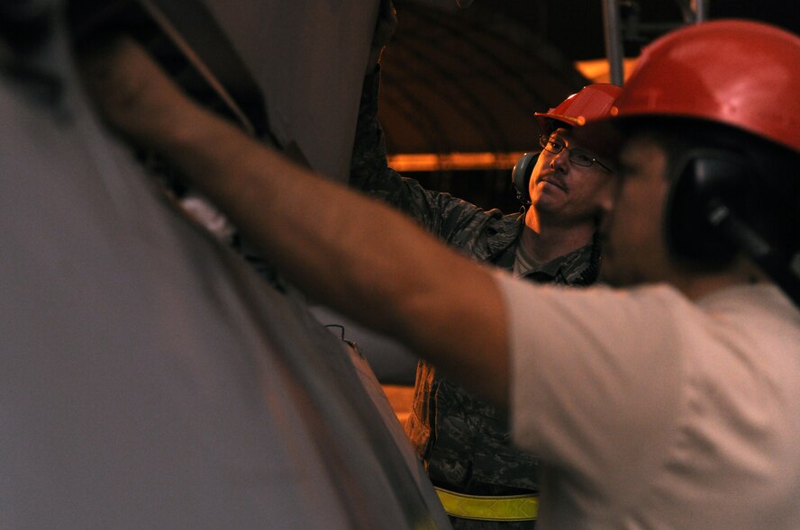 MOODY AIR FORCE BASE, Ga.-- Tech. Sgt. Joseph Mixson, 23rd Equipment Maintenance Squadron crash recovery, holds a section of a wing off an A-10C Thunderbolt II as Senior Airman Jesus Evaro, 23rd EMS crash recovery, puts padding inside the hinges during maintenance recently. Due to fair weather conditions, maintenance on the A-10 was done in the parking area instead of in a hangar. (U.S. Air Force photo/Airman 1st Class Benjamin Wiseman)(RELEASED)