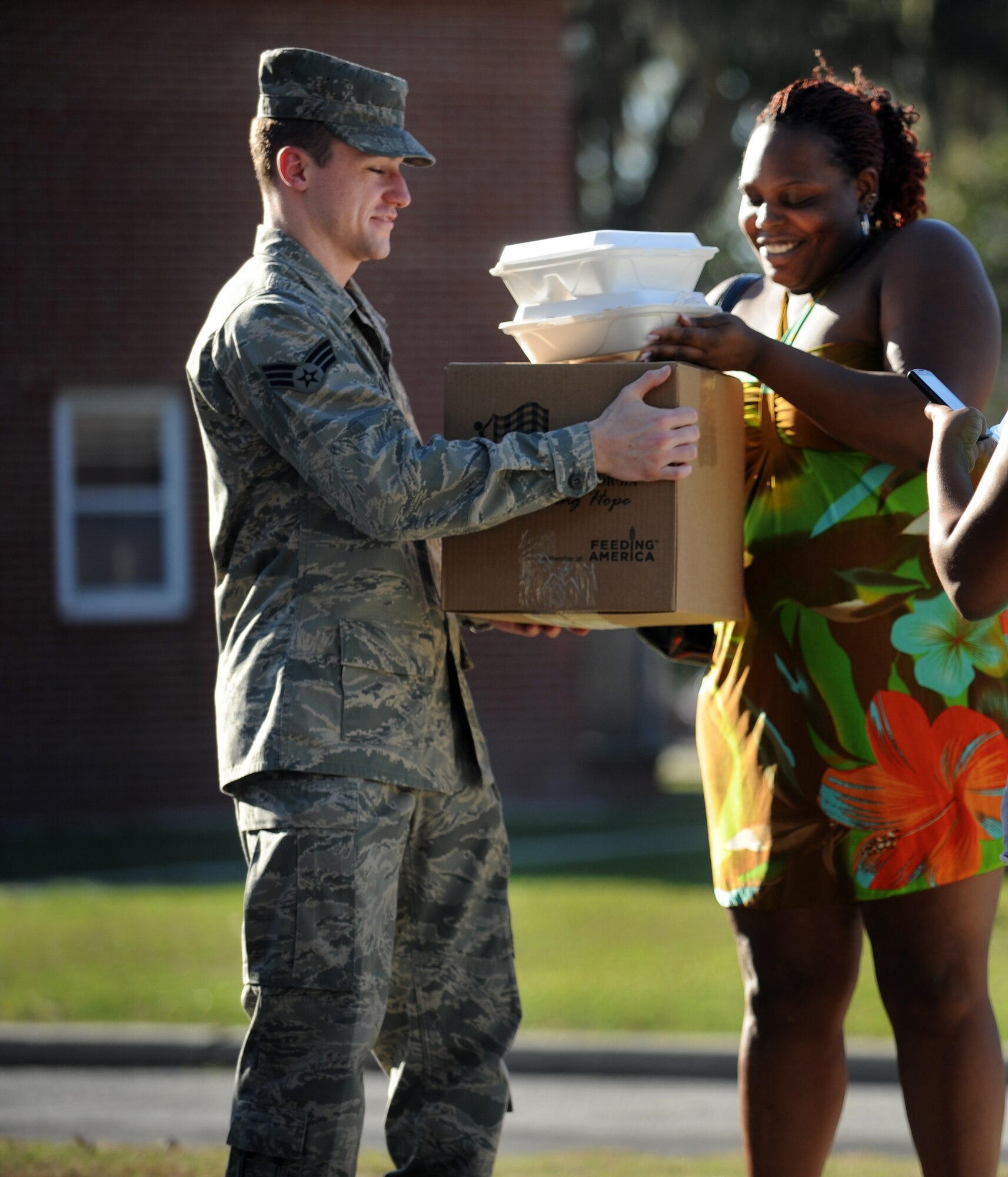 VALDOSTA, Ga. -- Senior Airman Joseph Oliver, 41st Rescue Group intelligence analyst, gives a box of food to an Ora Lee West resident during a ribbon cutting ceremony for the new Skills Success Center in downtown Valdosta Feb. 28. Airman Oliver, along with other Moody members, partnered with Second Harvest of South Georgia and Students in Free Enterprise to distribute 24,000 pounds of food to 400 families residing in Ora Lee West. (U.S. Air Force photo/Airman 1st Class Douglas Ellis)(RELEASED)
