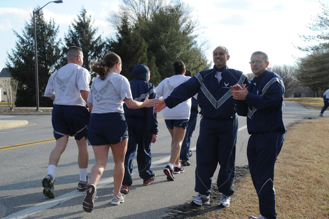 Col. Rudy Cachuela, 779th Medical Group commander, center, and Chief Master Sgt. Richard Brown, right, cheer on members of the 779th MDG as they come to the final stretch of a 5k run Feb. 25 on Joint Base Andrews, Md. Hundreds of Airmen participated in the run, which was the culmination of the 779th MDG’s Wingman Day. (U.S. Air Force photo/ Mike Martin)
