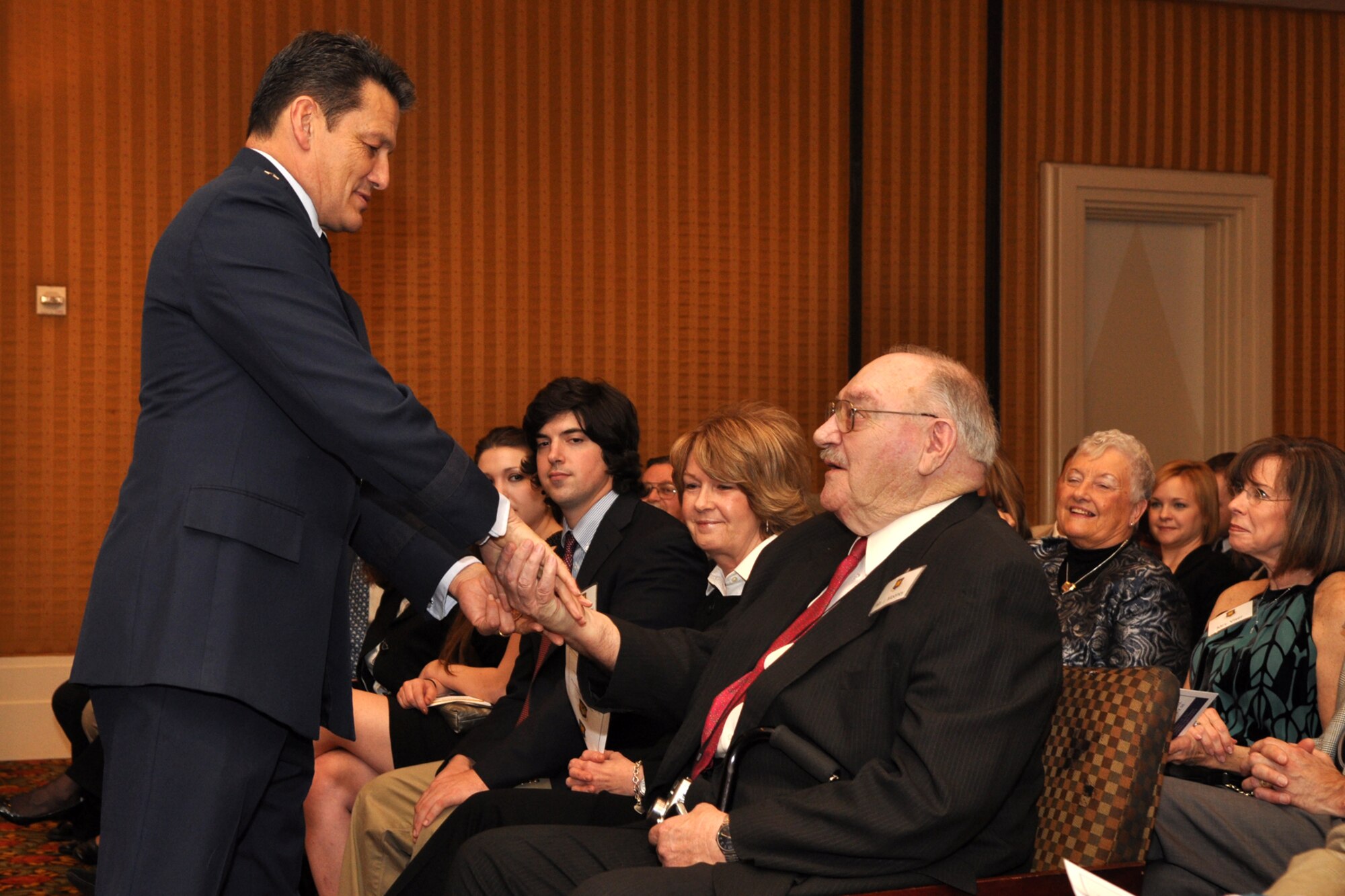 Maj. Gen. Frank Padilla, commander, 10th Air Force, presents a 10th Air Force challenge coin to John J. Mooney II, during the pinning-on ceremony for Brig. Gen. John J. Mooney III, at the Eldorado Hotel in Shreveport, La., Feb. 25, 2010. General Padilla also presented his personal commander's coin to Mr. Mooney. General Padilla was the presiding official for the ceremony. Approximately 70 family members and friends were in attendance, some traveling in from as far away as Maine for the event. General Mooney is the commander of the 307th Bomb Wing at Barksdale Air Force Base, La. (Photo by Jeff Walston)