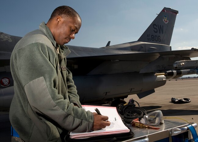 NELLIS AIR FORCE BASE, Nev. -- Airman 1st Class Darnell Womack, 20th Aircraft Maintenance Squadron crew chief, Shaw Air Force Base, S.C., goes over an inspection log for a F-16 Fighting Falcon during Red Flag 11-3, Feb. 24.  Red Flag is a realistic combat training exercise involving the air forces of the United States and its allies. The exercise is hosted north of Las Vegas on the Nevada Test and Training Range. (U.S. Air Force photo by Senior Airman Brett Clashman)