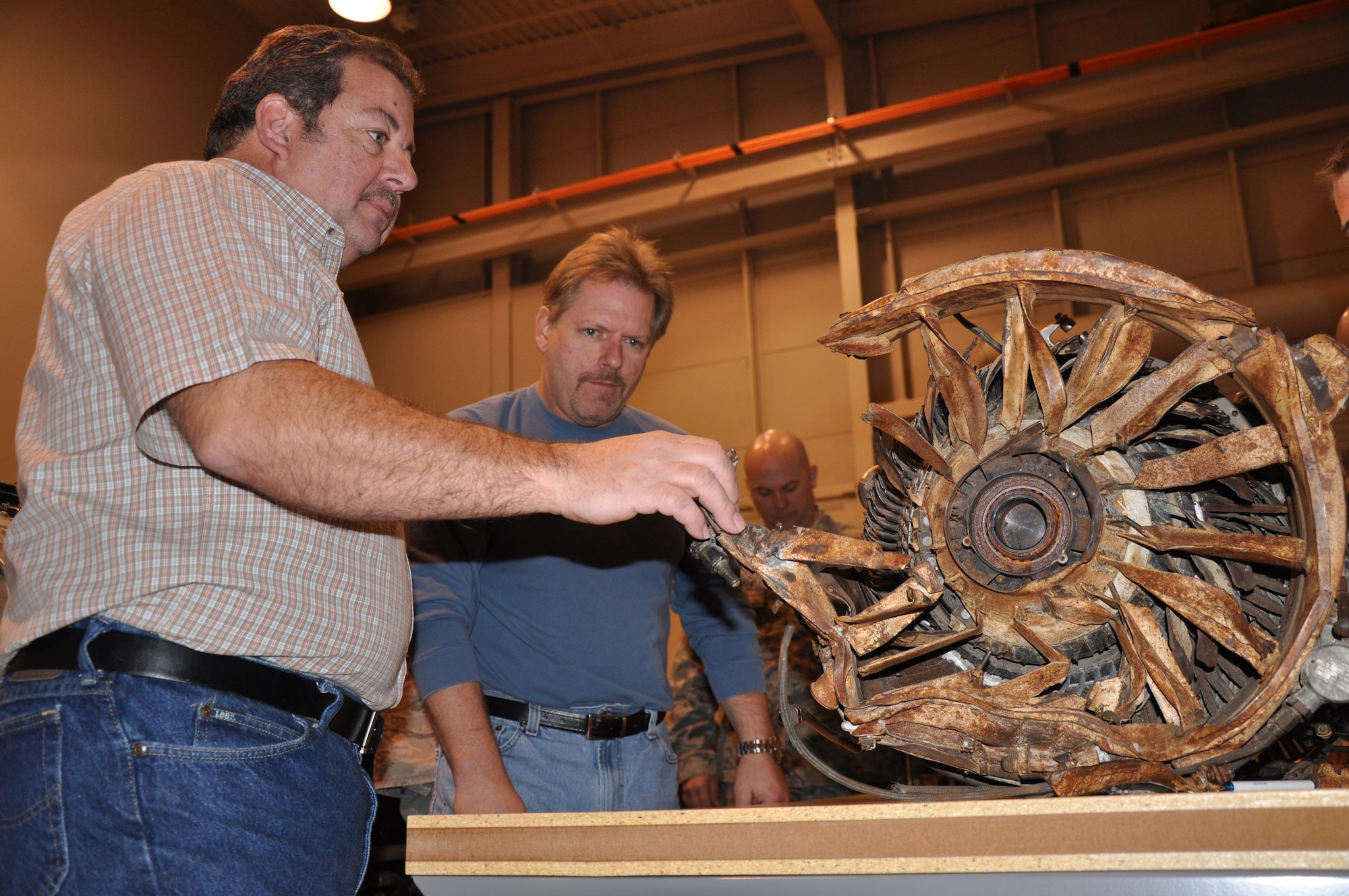 David Knauer, left, and Brad Bianchi look at a jet engine at the 361st Training Squadron's Jet Engine Mishap Investigation Course that was destroyed by a bird years ago. Mr. Knauer, a course instructor, and other teach the nine-day course to help develop investigative techniques to those who could potentially be part of an accident investigation board. Mr. Bianchi is a quality assurance inspecter for the 75th Propulsion Maintenance Group at Tinker Air Force Base, Okla. (U.S. Air Force photo/John Ingle)