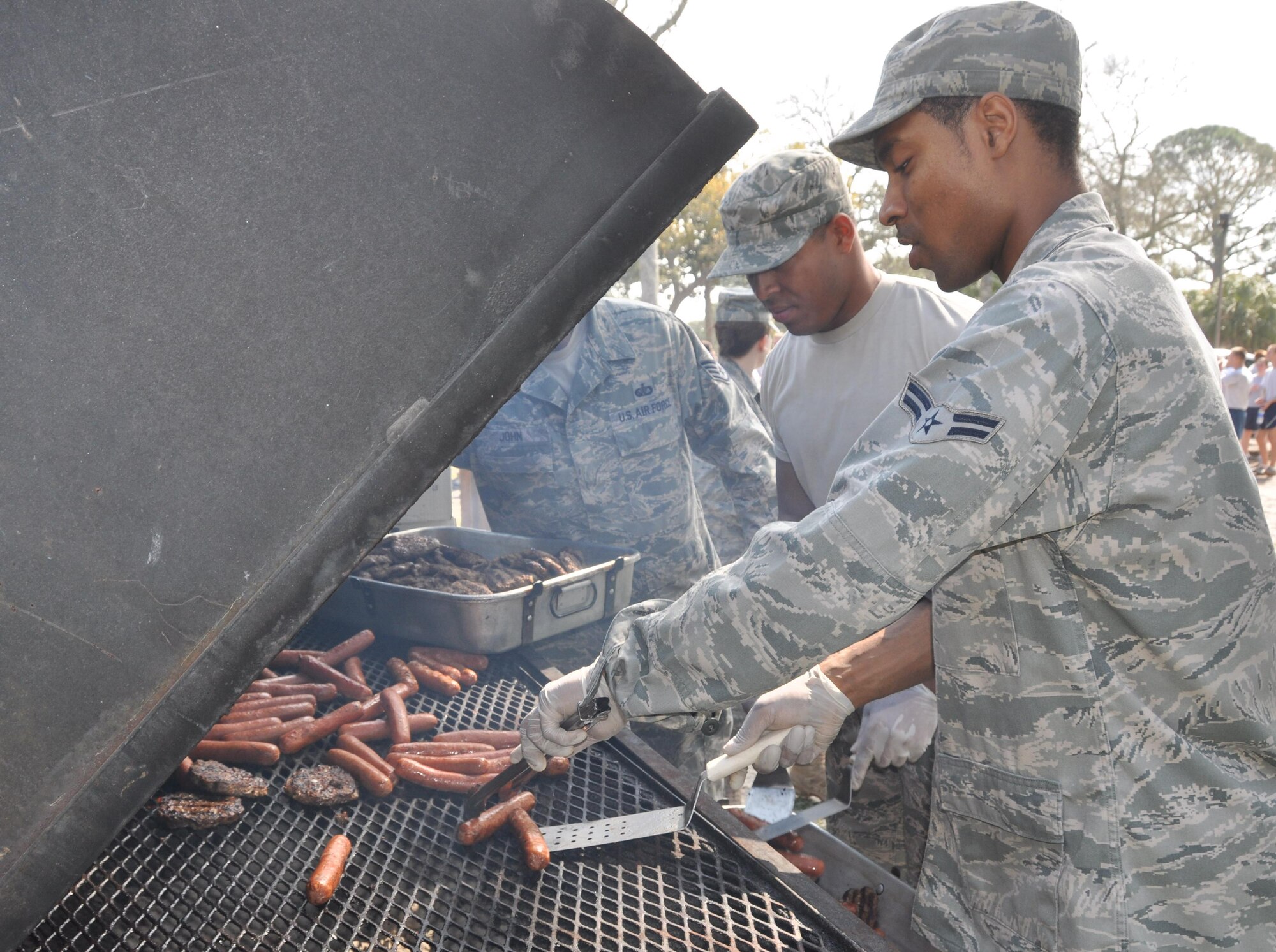 Airmen from the 325th Force Support Squadron cook hamburgers and hot dogs on the grill for the burger burn during Winter Wingman Day 2011 Feb. 25 at Heritage Park. (U.S. Air Force photo/Senior Airman Rachelle Elsea)