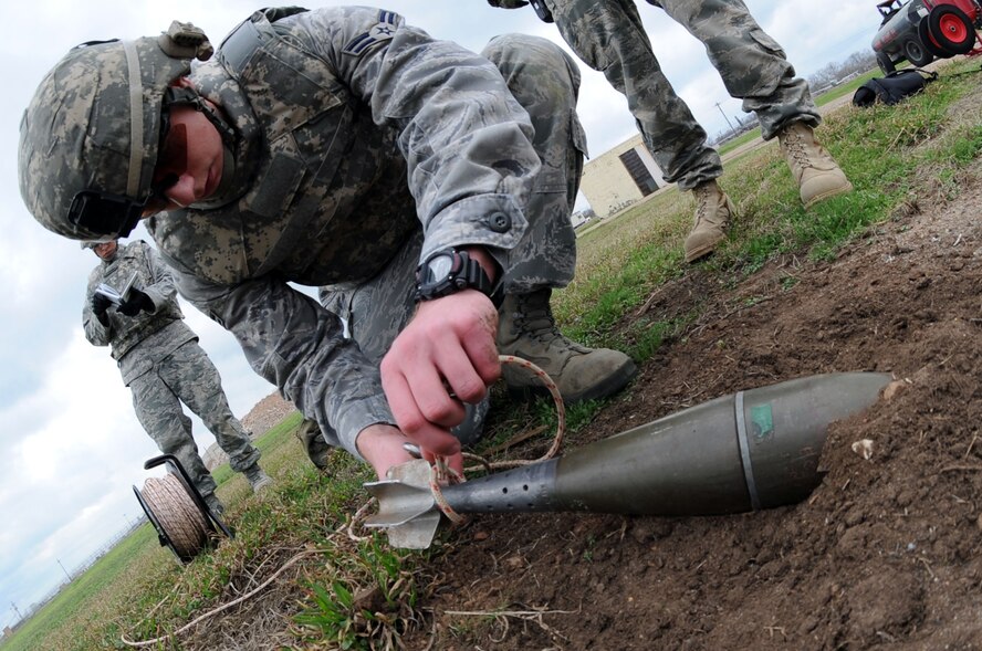 Airman 1st Class Kyle Miller, 2nd Civil Engineer Squadron Explosive Ordnance Disposal apprentice, ties a rope around a simulated unexploded ordnance to remotely pull the device during a Conventional Operational Readiness Exercise on Barksdale Air Force Base, La., Feb. 24, 2011. The unit's main mission is to detect, identify, recover and dispose of conventional, incendiary, chemical, biological and nuclear ordnance. (U.S. Air Force photo/Senior Airman Brittany Y. Bateman)(RELEASED)