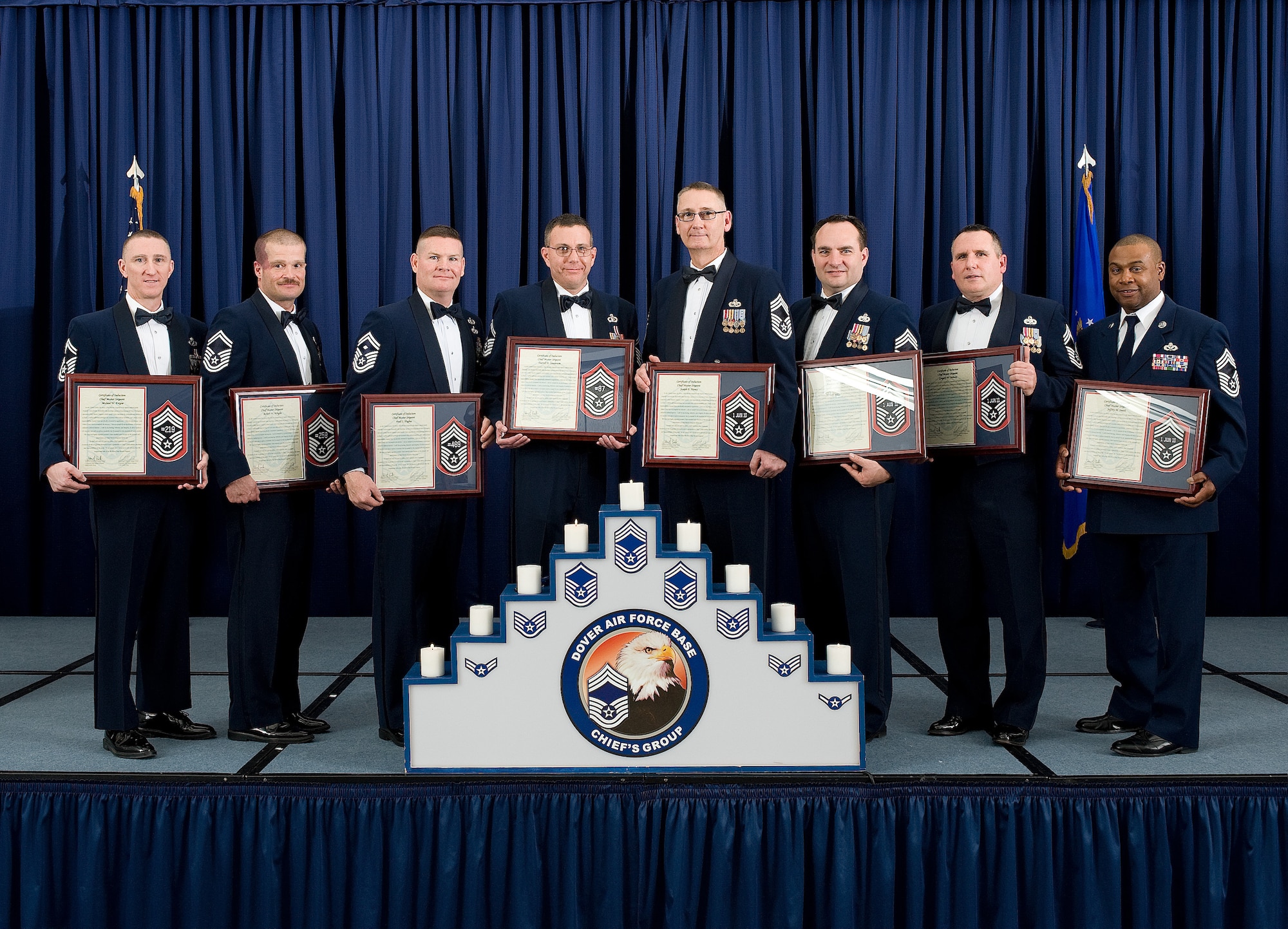 The newly inducted chief master sergeants come together with their plaques commemorating their achievement of joining the top one percent of the Air Force?s enlisted ranks Feb. 25, 2011, at The Landings Club, Dover Air Force Base, Del. The 2011 Chiefs Induction Ceremony honors those who have earned the honor of being called chief master sergeant. (U.S. Air Force photo/Jason Minto)