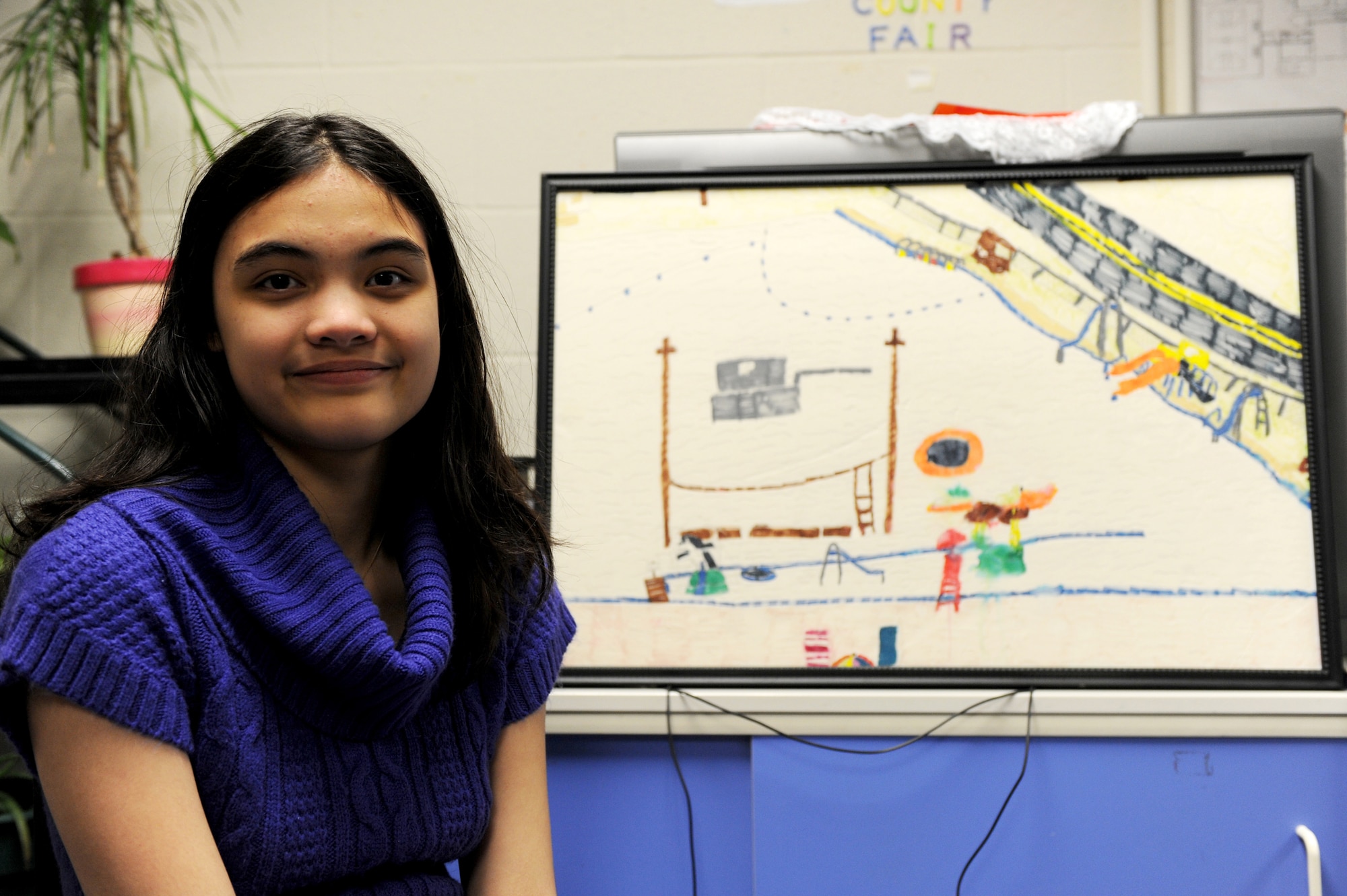 SEYMOUR JOHNSON AIR FORCE BASE, N.C. ? Melanie Green, 13, poses for a photo next to her playground drawing at the youth center here, Feb. 23, 2011. Melanie has high functioning autisim which is defined as a pervasive developmental disorder of children, characterized by impaired communication, excessive rigidity, and emotional detachment. Although Melanie is very artistic she is determined to become a veterinarian when she grows up. Melanie is the daughter of Master Sgt. Joshua Green, 4th Aircraft Maintenance Squadron. (U.S. Air Force photo/Staff Sgt. Courtney Richardson)(RELEASED)