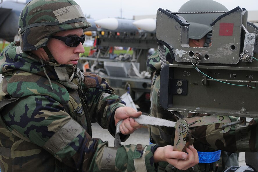 Senior Airman Matthew Curiale, 44th Aircraft Maintenance Unit weapons load crew member, fastens the strap of the munitions trailer during Beverly High 11-03, a local operational readiness exercise at Kadena Air Base, Japan, March 1. Fastening the straps ensures that the missiles are secure and do not risk falling off when they are moved. (U.S. Air Force photo/ Staff Sgt. Darnell T. Cannady)