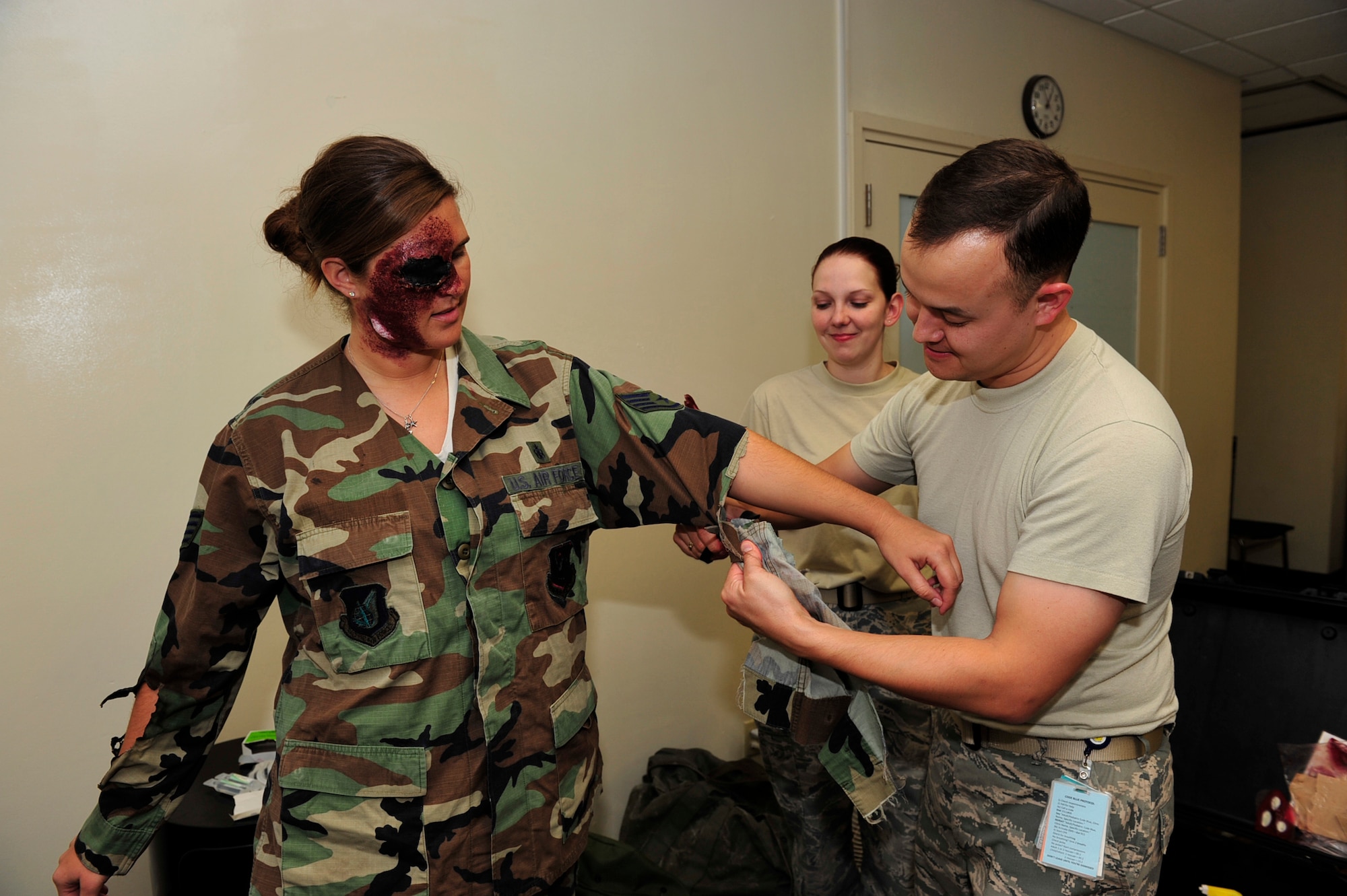 Master Sgt. Nicholaus Stopfer and Staff Sgt. Cynthia Evans (right), both with the 18th Dental Squadron, apply moulage to Airman 1st Class Chelsea Rittenhouse (left),  a medical technician with the 18th Medical Operations Squadron, during the local operation readiness exercise here at Kadena Air Base, Mar. 1. The LORE prepares Kadena personnel for any scenario that may occur in a real world contingency. (U.S. Air Force photo/ Staff Sgt. Lakisha A. Croley)