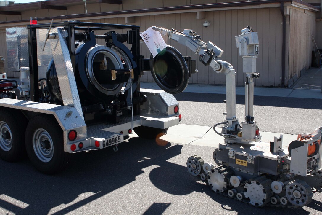 A bomb disposal robot places a simulated suspicious package in a explosive container during an all hazard protection exercise March 1. Emergency personnel from Marine Corps Air Station Miramar participated in the exercise to gain hands on experience responding to a simulated bomb sent to the MCAS Miramar Post Office.
