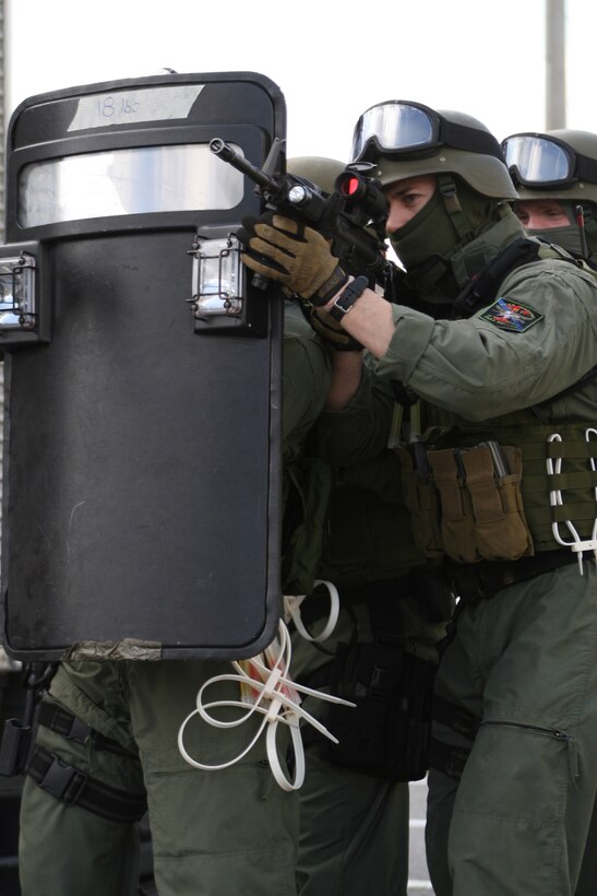 The Provost Marshal’s Office Special Reaction Team practices with a riot shield before taking part in a simulation during exercise Active Shield here March 2 outside of the fire training tower. The simulation involved several suspects taking two hostages as the SRT attempted to gain access the building.