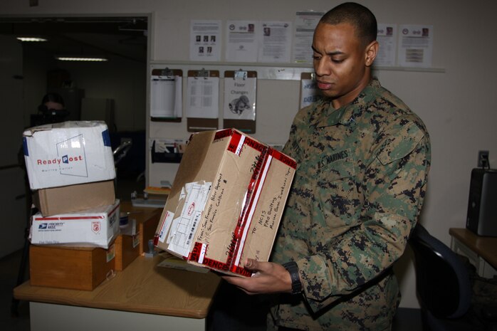 Lance Cpl. Dominique L. Butts, a postal clerk with Headquarters and Headquaters Squadron, inspects a suspicious package that arrived at the Post Office March 1 during excercise Active Shield 2011 .