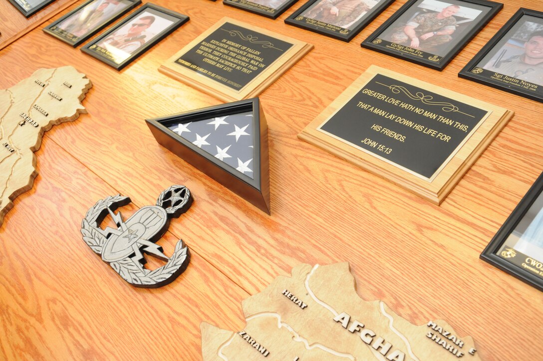 A memorial tribute that shows 35 explosive ordnance disposal Marines who have died supporting operations in Iraq and Afghanistan and on duty, stands at the Combined Explosive Ordnance Disposal Unit building at the Marine Corps Air Station in Yuma, Ariz., March 1, 2011. "Every EOD tech on this wall we know, either personally or we've worked with them," said Chief Warrant Officer 2 Simon Wade, unit officer in charge. "There's a story behind every one of these guys." When the wall was first dedicated, it was a simple one-faced structure that only had 19 faces on it, and wood cutouts of Iraq and Afghanistan. The wall has since expanded in commemorating the deceased, the country models far more detailed with the locations of major cities and rivers etched into them, courtesy of Marine Wing Support Squadron 371 combat engineers.