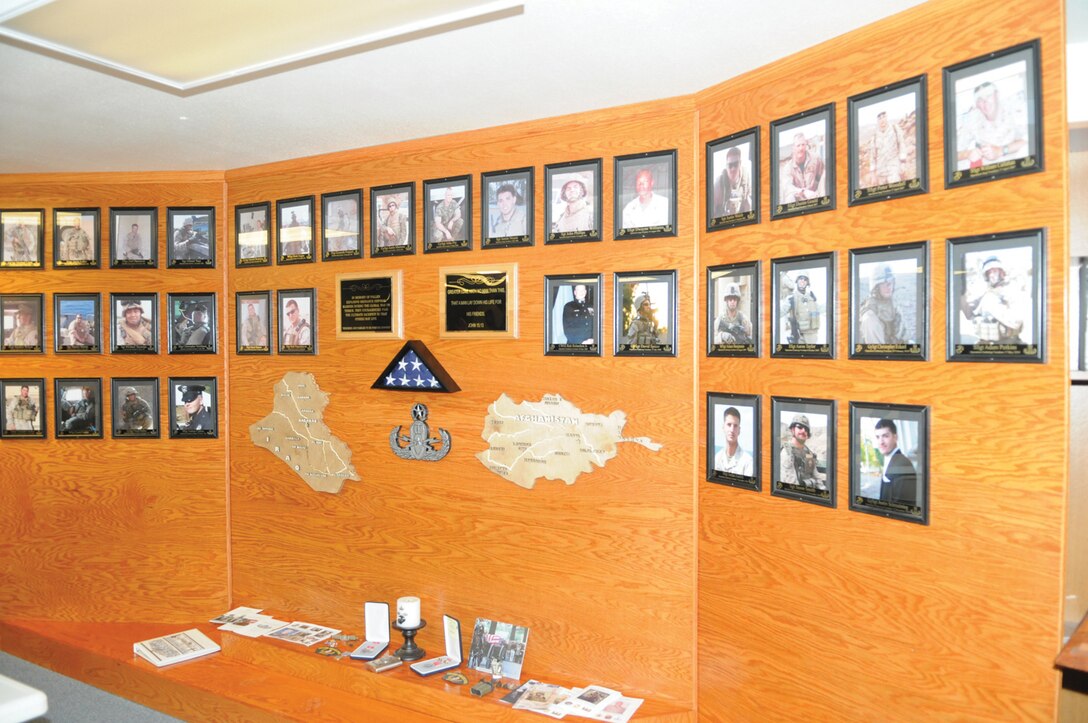 A memorial tribute that shows 35 explosive ordnance disposal Marines who have died supporting operations in Iraq and Afghanistan, and on duty, stands at the Combined Explosive Ordnance Disposal Unit building at the Marine Corps Air Station in Yuma, Ariz., March 1, 2011. “Every EOD tech on this wall we know, either personally or we’ve worked with them,” said Chief Warrant Officer 2 Simon Wade, unit officer in charge. “There’s a story behind every one of these guys.” When the wall was first dedicated, it was a simple one-faced structure that only had 19 faces on it, and wood cutouts of Iraq and Afghanistan. The wall has since expanded in commemorating the deceased, the country models far more detailed with the locations of major cities and rivers etched into them, courtesy of Marine Wing Support Squadron 371 combat engineers.