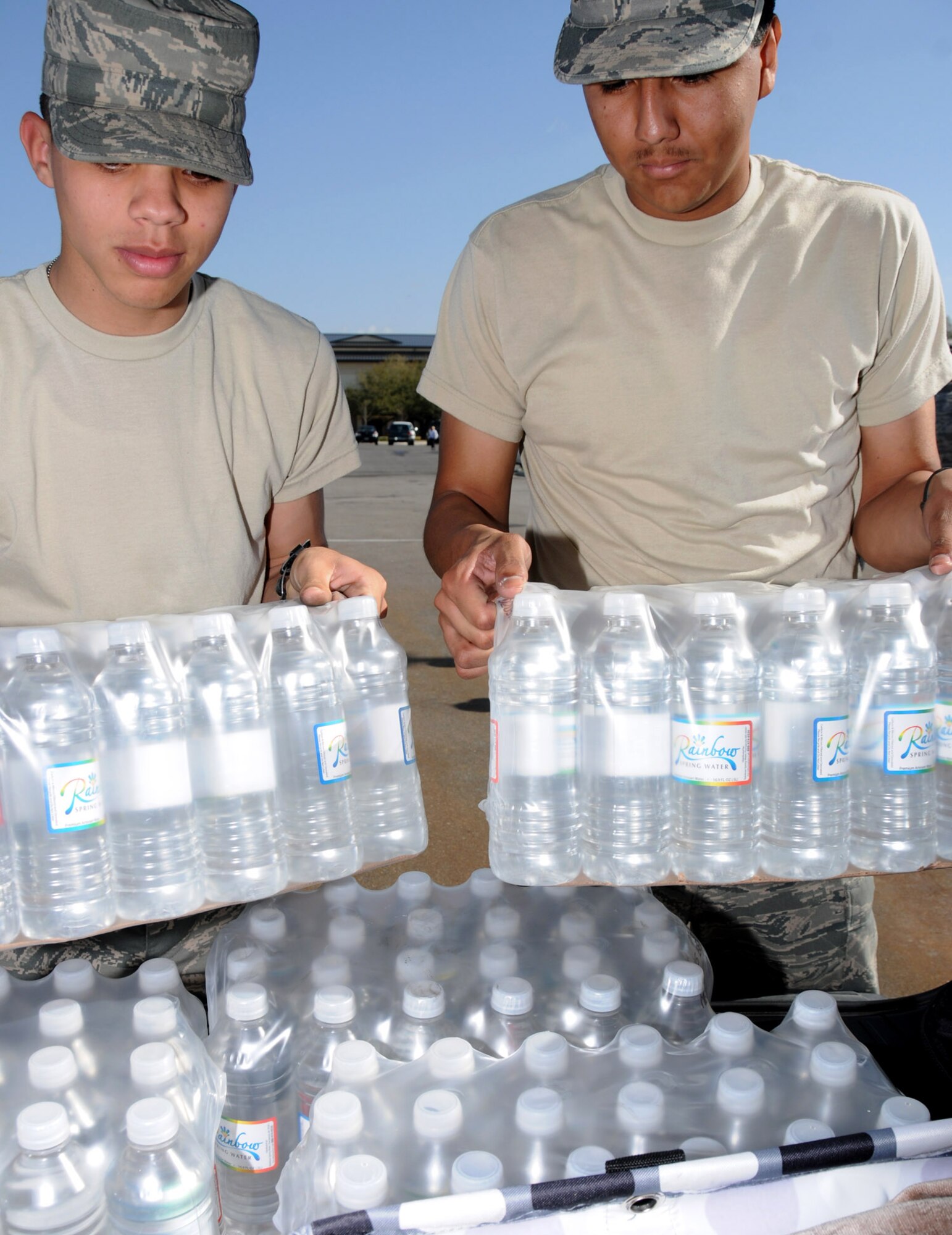 Airman Basic Javier Peralty and Airman Hector Sanchez, 336th TRS students, load cases of water for base housing residents at the Bay Breeze Event Center Friday. Bottled water has also been distributed to dorm residents, lodging guests and the child development center and youth center.  (U.S. Air Force photo by Kemberly Groue)