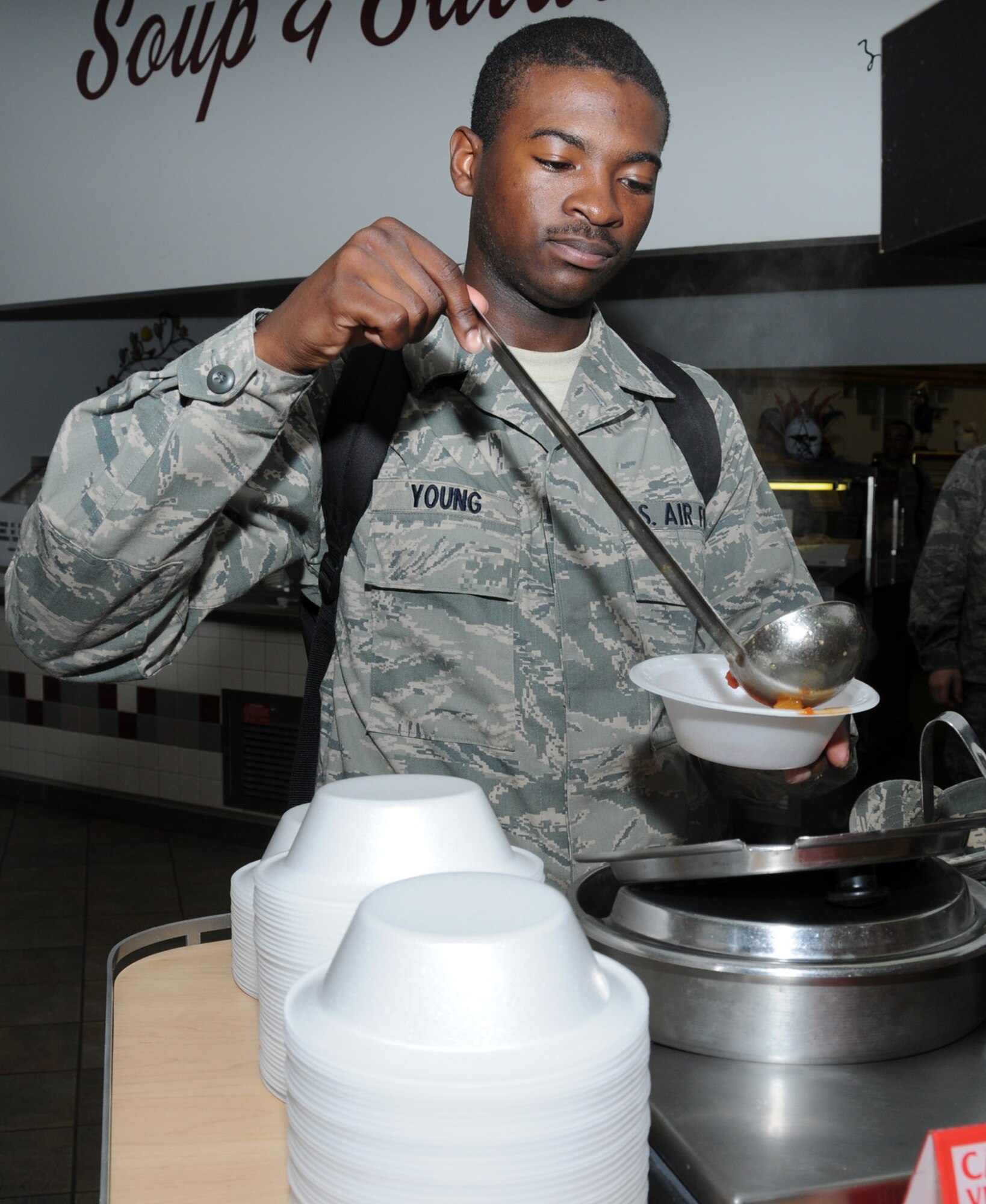 Airman 1st Class Draylon Young, 336th Training Squadron student, ladles soup into a styrofoam bowl at the Azalea Dining Facility. In addition to using disposable dinnerware, canned and bottled beverages were served instead of fountain drinks.  (U.S. Air Force photo by Kemberly Groue)