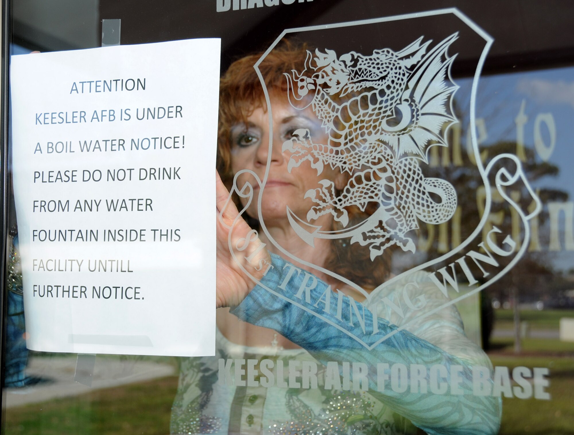 Donna Flynn posts a sign at the Dragon Fitness Center reminding patrons not to use
the drinking fountains.  (U.S. Air Force photo by Kemberly Groue)