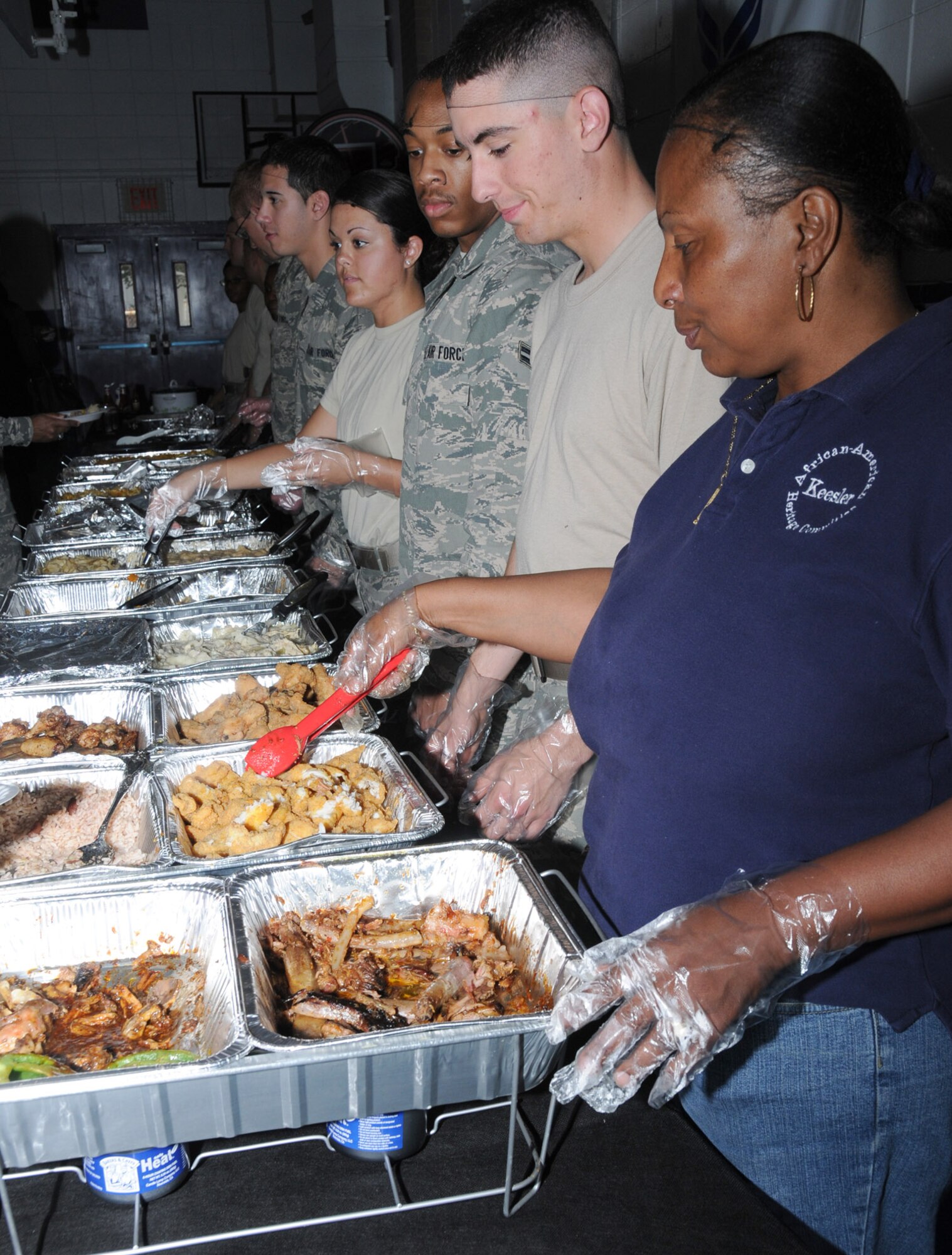 From left, Airman 1st Class William Cashman, Airman Patricia Philpot, Airman Taylor Donnellan and Sharon Floyd serve baked chicken, fried catfish, collard greens, green bean casserole and macaroni and cheese at the soul food sampling sponsored by the African-American Heritage Committee Feb. 25 at the youth center.  The Airmen are students in the 336th Training Squadron and Ms. Floyd is from the 338th TRS.  (U.S. Air Force photo by Kemberly Groue)