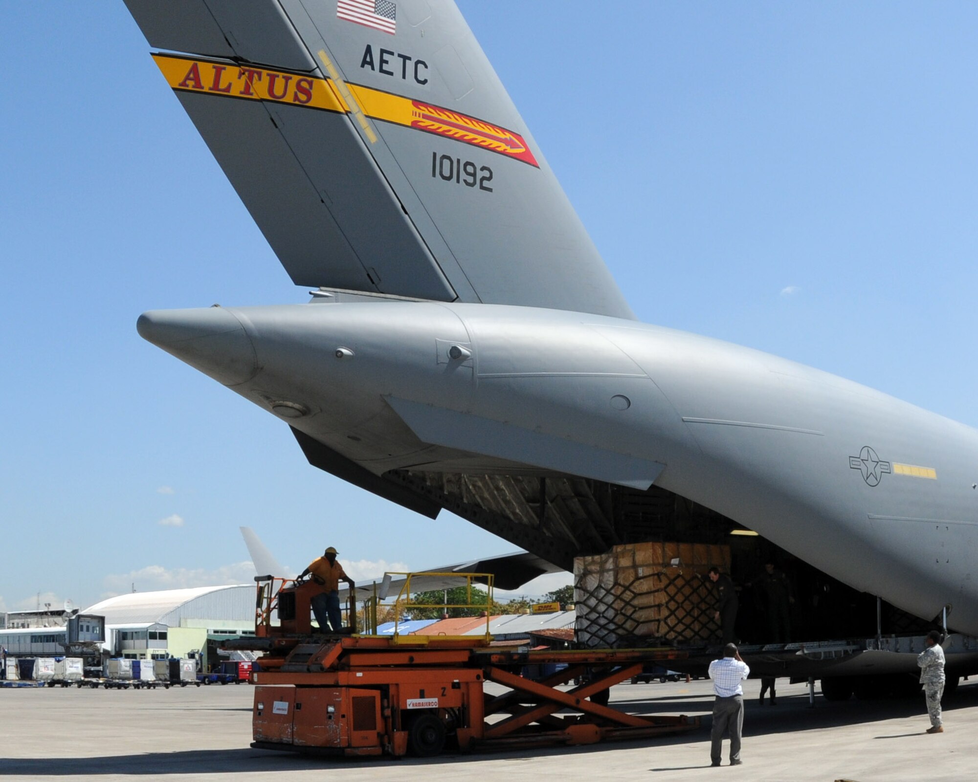 JOINT BASE CHARLESTON, S.C. -- An employee of Port-au-Prince Airport, Haiti, unloads cargo off of a C-17 Globemaster III from Altus Air Force Base, Okla. The crew from the 58th Airlift Squadron delivered 10 pallets of building materials and food in support of relief operations in Haiti, Feb. 19. The delivery was possible because of the Denton Program, which allows donors to use space available on U.S. military cargo aircraft to transport humanitarian goods and equipment to people in need. (U.S. Air Force photo by Airman 1st Class Kenneth W. Norman/ Released 97th Air Mobility Wing Public Affairs)