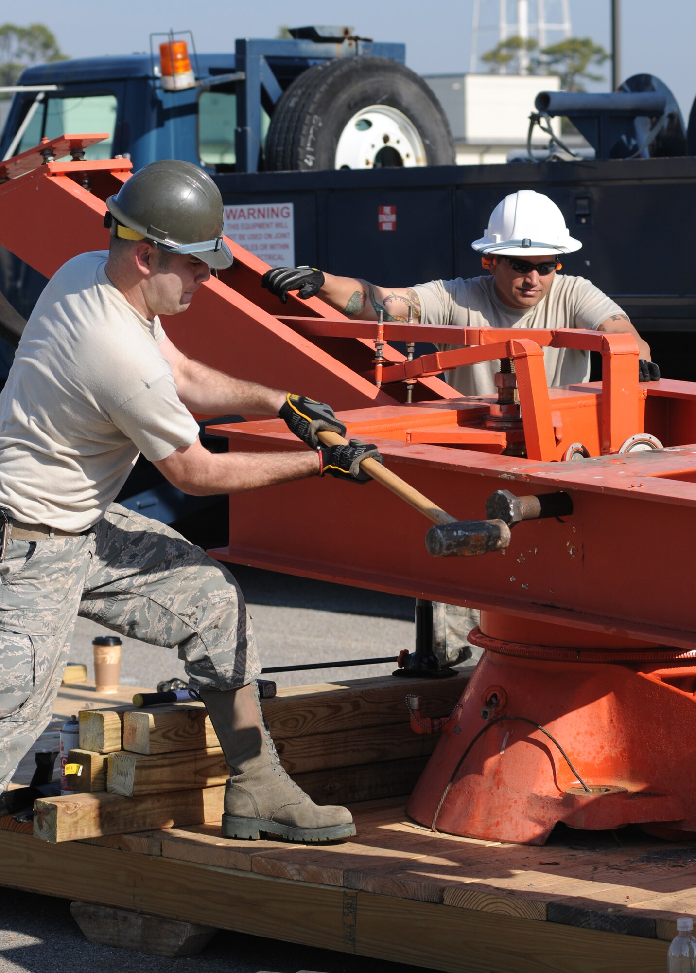 Staff Sgt. Steven Flint, left, 85th EIS, hammers out a retaining pin in the antenna pedestal as the team chief, Tech Sgt. Walt Ferrell, observes other Airmen perform the finishing touches on the radar dismantling.  (U.S. Air Force photo by Kemberly Groue)