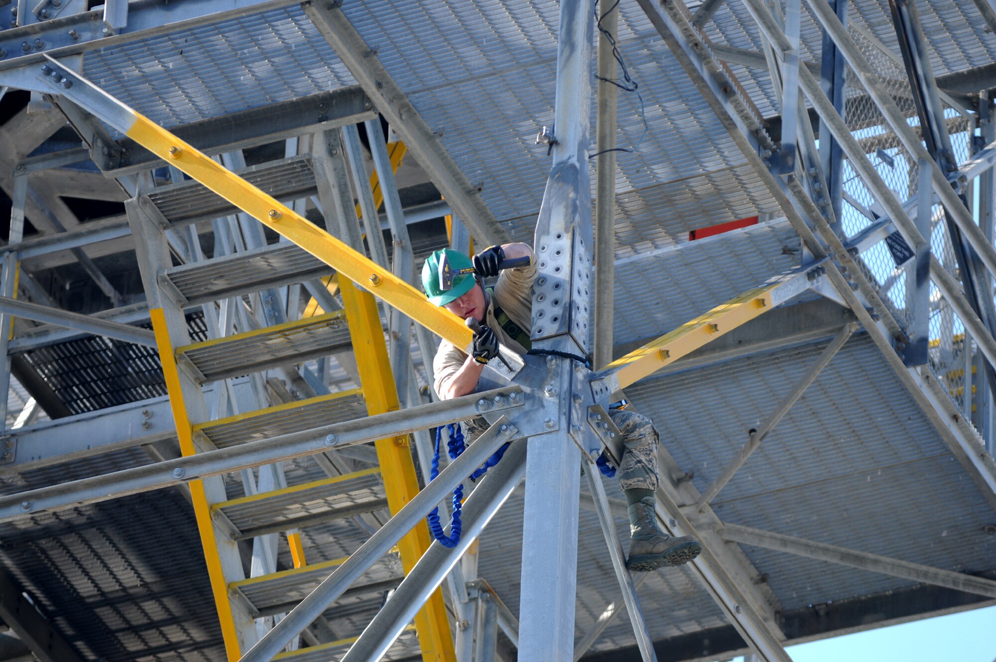 Perched precariously at the intersection of stairways and steel, Staff Sgt. Curtis Perkins, 85th EIS, removes bolts from an angle plate on the legs of the radar tower.  (U.S. Air Force photo by Kemberly Groue)