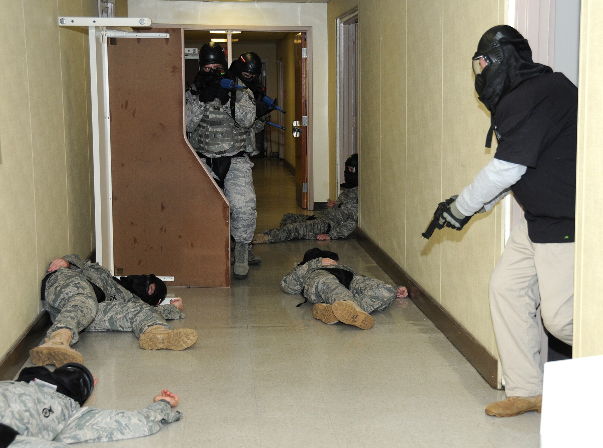 From left, Staff Sgt. Austin Sutton and Senior Airman Joseph Glover use small unit tactics to clear a building as Master Sgt. Christopher Rash portrays a gunman during the 81st Security Forces Squadron’s active shooter exercise in Hangar 3, Feb. 22. (U.S. Air Force photo by Kemberly Groue)
